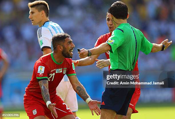 Referee Milorad Mazic speaks to Ashkan Dejagah and Masoud Shojaei of Iran during the 2014 FIFA World Cup Brazil Group F match between Argentina and...