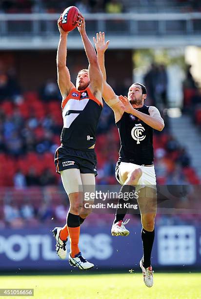 Shane Mumford of the Giants competes for the ball against Robert Warnock of the Blues during the round 14 AFL match between the Greater Western...