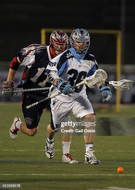 Brodie Merrill of the Boston Cannons chases Bobby Dattilo of the Ohio Machine down the field during a game on June 21, 2014 at Harvard Stadium in...