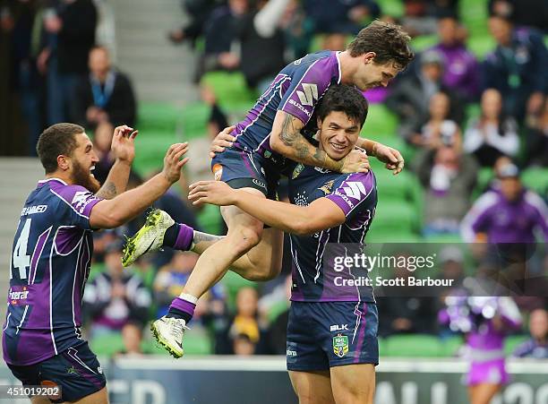 Jordan McLean of the Strom is congratulated by his teammates after scoring a try during the round 15 NRL match between the Melbourne Storm and the...