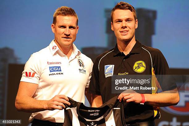 Collingwood coach Nathan Buckley presents Matthew Scharenberg with the Collingwood guernsey during the 2013 NAB AFL Draft on November 21, 2013 on the...
