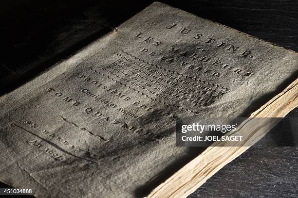 This picture taken on May 21, 2014 in Boulogne-Billancourt, outside Paris, shows an edition of French writer the Marquis de Sade's ''Justine - The...