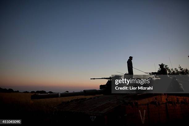 Israeli soldiers stand on a Merkava tank on the Israeli-Syrian border near Quneitra on June 22, 2014 Israeli-annexed Golan Heights. An Israeli teen...