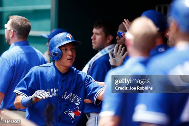 Munenori Kawasaki of the Toronto Blue Jays celebrates with teammates in the dugout after scoring a run in the third inning of the game against the...