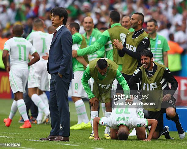 Islam Slimani of Algeria celebrates with teammates after scoring his team's first goal as head coach Hong Myung-Bo of South Korea looks on during the...