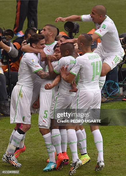 Algeria's defender Rafik Halliche celebrates scoring with teammates during a Group H football match between South Korea and Algeria at the Beira-Rio...