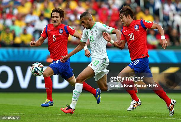 Islam Slimani of Algeria controls the ball to score his team's first goal past Kim Young-Gwon and Hong Jeong-Ho of South Korea during the 2014 FIFA...