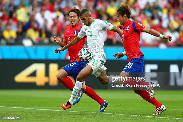 Islam Slimani of Algeria controls the ball to score his team's first goal past Kim Young-Gwon and Hong Jeong-Ho of South Korea during the 2014 FIFA...