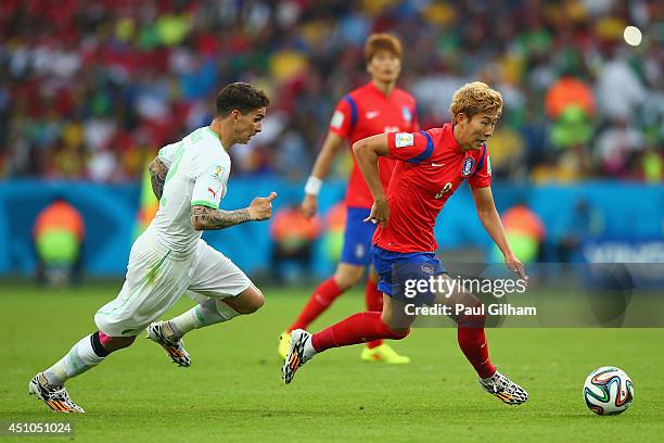 Son Heung-Min of South Korea controls the ball as Carl Medjani of Algeria gives chase during the 2014 FIFA World Cup Brazil Group H match between...