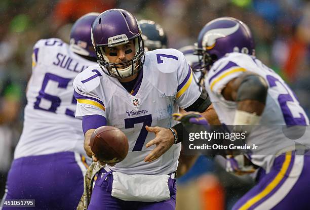 Quarterback Christian Ponder of the Minnesota Vikings looks to hand off to running back Adrian Peterson against the Seattle Seahawks at CenturyLink...