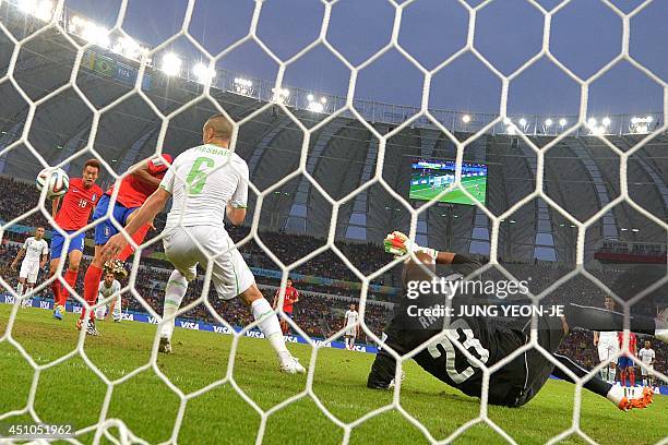 South Korea's forward Koo Ja-Cheol scores past Algeria's defender Djamel Mesbah and Algeria's goalkeeper Rais Mbohli during a Group H football match...