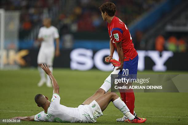 Algeria's forward Islam Slimani is helped by South Korea's defender Hong Jeong-Ho during a Group H football match between South Korea and Algeria at...