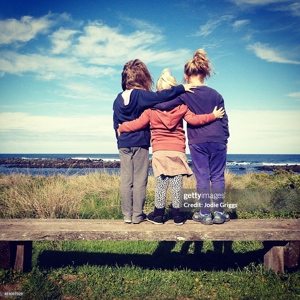 Children standing together looking out at the sea