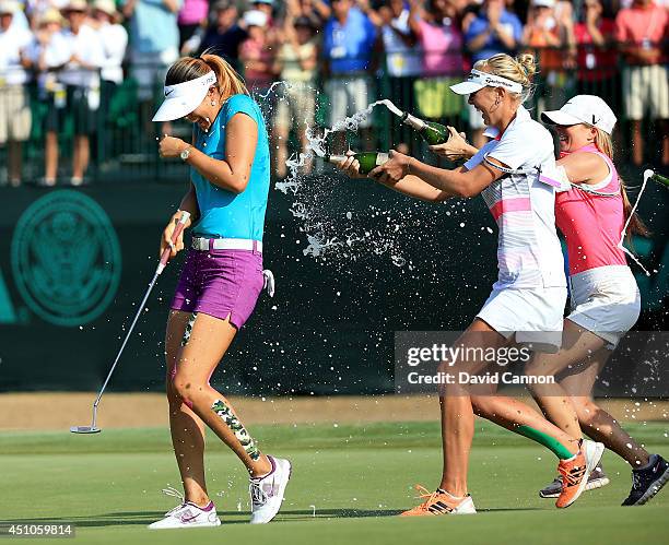 Michelle Wie of the USA is drenched with champagne by Jessica Korda and Jamie Kuhn after holing the winning putt at the par 4, 18th hole during the...