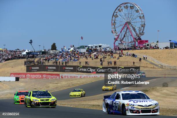 Brian Vickers, driver of the Aaron's Dream Machine Toyota, and Paul Menard, driver of the Richmond / Menards Chevrolet, lead a pack of cars during...
