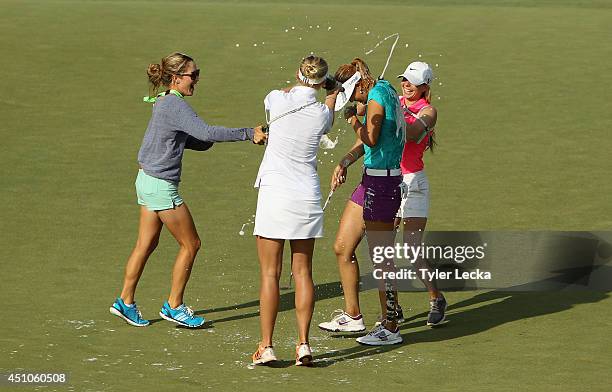 Michelle Wie of the USA is drenched with champagne by Jessica Korda, Jaye Marie Green and Jamie Kuhn after holing the winning putt during the final...