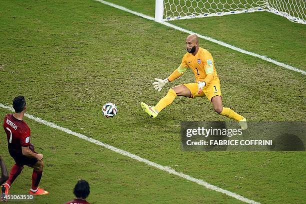 Goalkeeper Tim Howard makes a save during a Group G football match between USA and Portugal at the Amazonia Arena in Manaus during the 2014 FIFA...