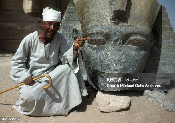 An Egyptian tour guide points out a statue head at Luxor Temple in Luxor, Egypt.