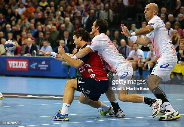 Thomas Mogensen of Flensburg challenges Torsten Jansen of Hamburg for the ball during the VELUX EHF Handball Champions League group D match between...