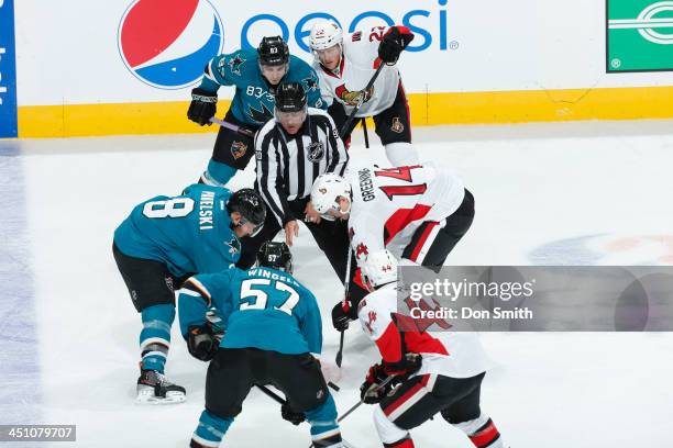 Joe Pavelski of the San Jose Sharks faces off against Colin Greening of the Ottawa Senators during an NHL game on October 12, 2013 at SAP Center in...