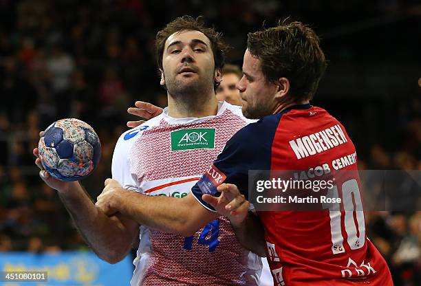 Thomas Mogensen of Flensburg challenges Joan Canellas of Hamburg for the ball during the VELUX EHF Handball Champions League group D match between SG...