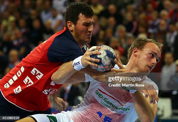 Drasko Nenadic of Flensburg challenges Henrik Toft Hansen of Hamburg for the ball during the VELUX EHF Handball Champions League group D match...