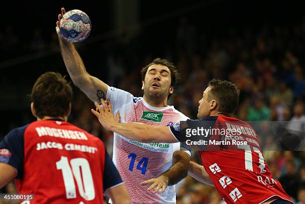 Michael Knudsen of Flensburg challenges Joan Canellas of Hamburg for the ball during the VELUX EHF Handball Champions League group D match between SG...