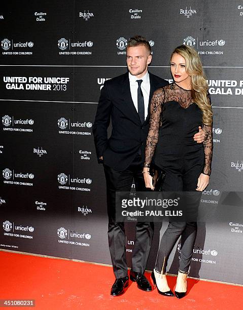Manchester United's English midfielder Tom Cleverley and partner Georgina Dorsett pose for photographs as they arrive for a gala dinner in aid of...