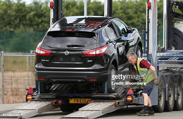 An employee prepares a new Nissan Qashqai SUV automobile, produced by Nissan Motor Co., ahead of delivery to Toomey Motor Group's car dealership in...