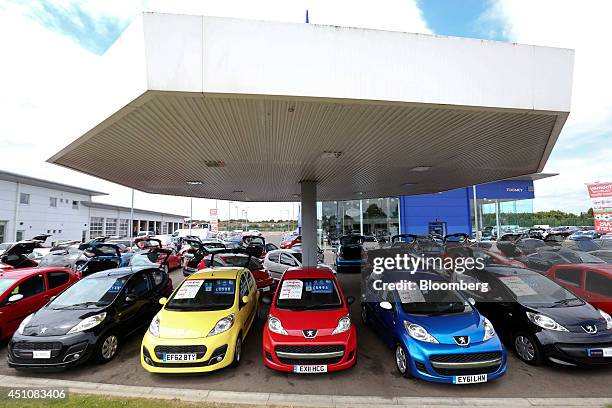 Second-hand Peugeot automobiles, produced by PSA Peugeot Citroen, stand parked for sale outside Toomey Motor Group's car dealership in Rochford,...