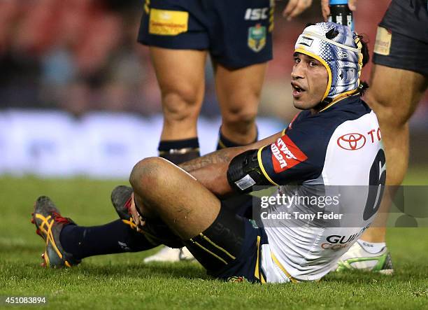 Johnathan Thurston of the Cowboys holds his leg after getting injured during the round 15 NRL match between the Newcastle Knights and the North...