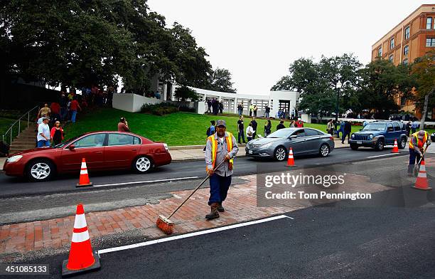 Dallas city workers repair the asphalt on Elm Street in Dealey Plaza as people visit Dealey Plaza on November 21, 2013 in Dallas, Texas. People...