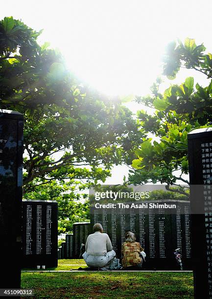 People pray for the victims in front of the Cornerstone of Peace memorial at the 'Mabuni-no-oka', in Peace Memorial Park as Japan marks the 69th...