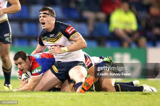 Ethan Lowe of the Cowboys tackles James McManus of the Knights during the round 15 NRL match between the Newcastle Knights and the North Queensland...