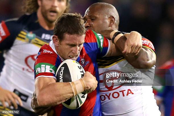 Kurt Gidley of the Knights is tackled by the Cowboys defence during the round 15 NRL match between the Newcastle Knights and the North Queensland...