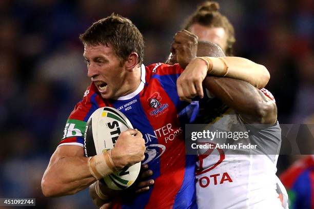 Kurt Gidley of the Knights is tackled by the Cowboys defence during the round 15 NRL match between the Newcastle Knights and the North Queensland...