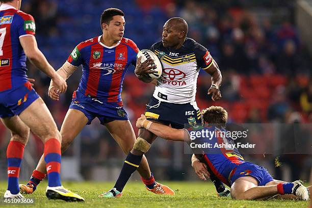 Robert Lui of the Cowboys is tackled by Joseph Tapine and Adam Clydesdale of the Knights during the round 15 NRL match between the Newcastle Knights...