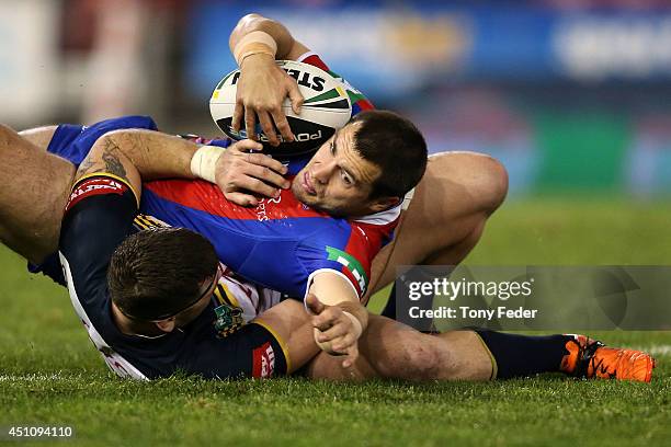 James McManus of the Knights is tackled during the round 15 NRL match between the Newcastle Knights and the North Queensland Cowboys at Hunter...