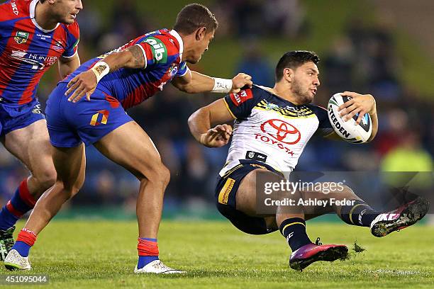 Curtis Rona of the Cowboys is tackled by Dane Gagai of the Knights during the round 15 NRL match between the Newcastle Knights and the North...