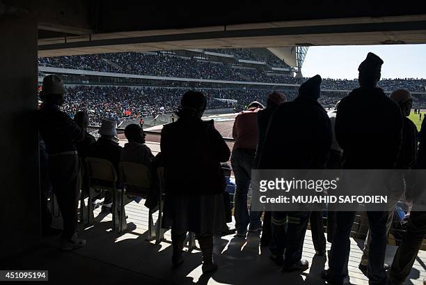 Striking miners stands at the Royal Bafokeng stadium near the northwestern town of Rustenburg, some 200 km northwest of Johannesburg on June 23 as...