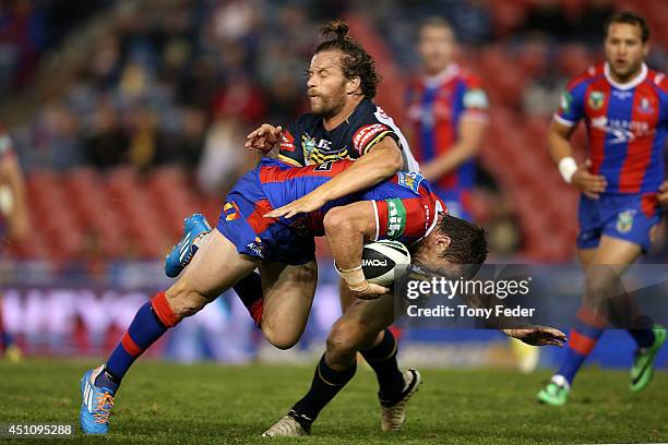 Kurt Gidley of the Knights is tackled by the Cowboys defence during the round 15 NRL match between the Newcastle Knights and the North Queensland...