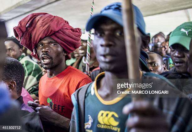 South African miners sing while taking part in a rally where the Association of Mineworkers and Construction Union's leader announced the end of...