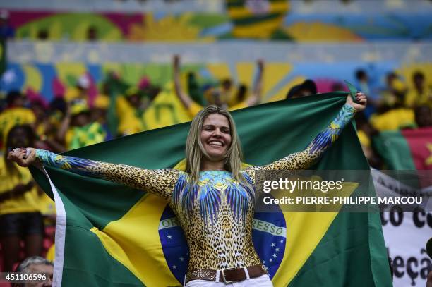 Brazilian supporter cheers prior to a Group A football match between Cameroon and Brazil at the Mane Garrincha National Stadium in Brasilia during...