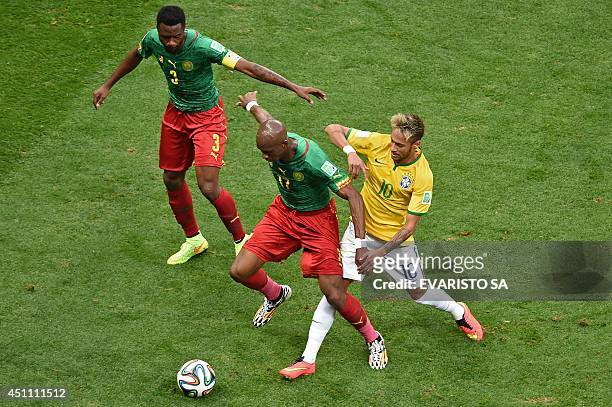 Brazil's forward Neymar and Cameroon's midfielder Stephane Mbia vie for the ball during the Group A football match between Cameroon and Brazil at the...