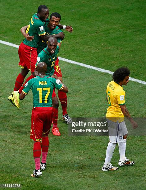 Joel Matip of Cameroon celebrates scoring his team's first goal with teammates as Marcelo of Brazil looks on during the 2014 FIFA World Cup Brazil...