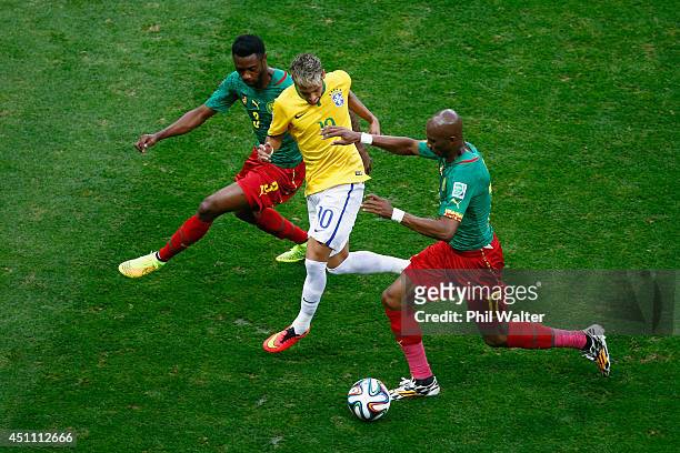 Neymar of Brazil is challenged by Nicolas N'Koulou and Stephane Mbia of Cameroon during the 2014 FIFA World Cup Brazil Group A match between Cameroon...