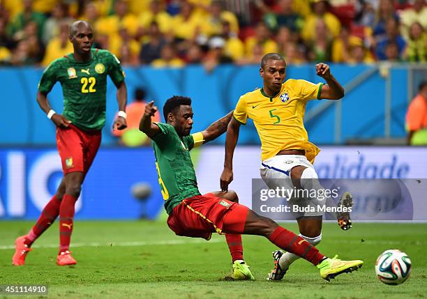 Fernandinho of Brazil scores his team's fourth goal against Nicolas N'Koulou of Cameroon during the 2014 FIFA World Cup Brazil Group A match between...