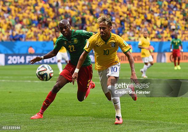 Neymar of Brazil competes for the ball with Allan Nyom of Cameroon during the 2014 FIFA World Cup Brazil Group A match between Cameroon and Brazil at...