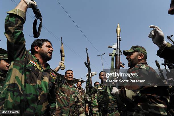 Iraqi Shiites of the Mahdi Army militia loyal to cleric Moqtada al-Sadr chant with weapons raised as they vow to fight ISIS in a show of strength in...