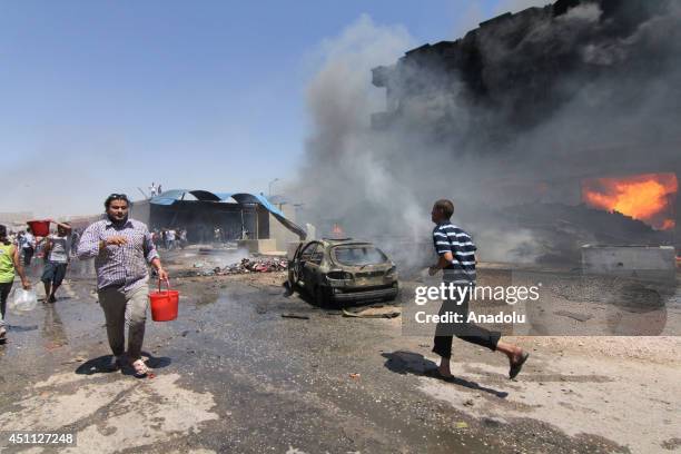 Benghazis carpet and furniture market was turned into an inferno as several shops and vehicles are burnt, causing hundreds of thousands of dinars...